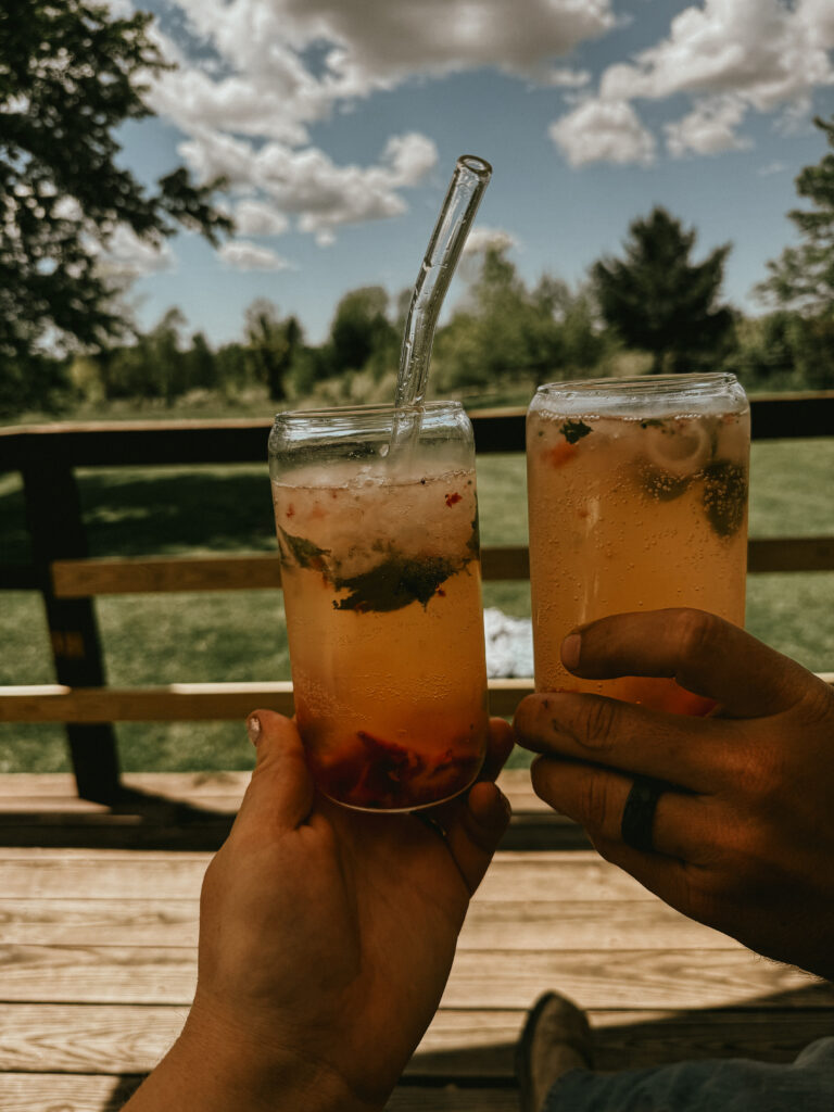Glass of strawberry lemonade with garden in background