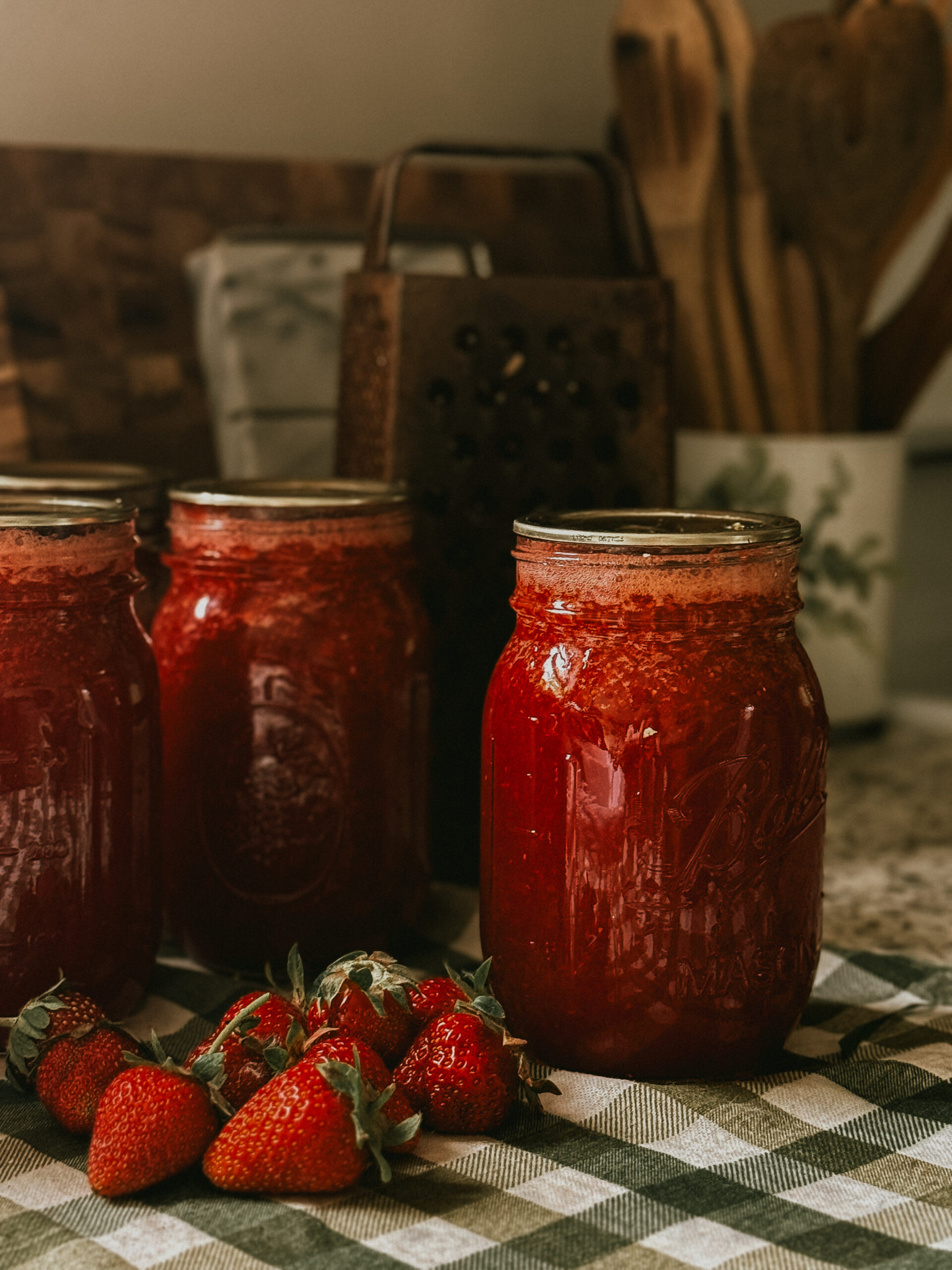 Strawberry preserves in jars on tea towel