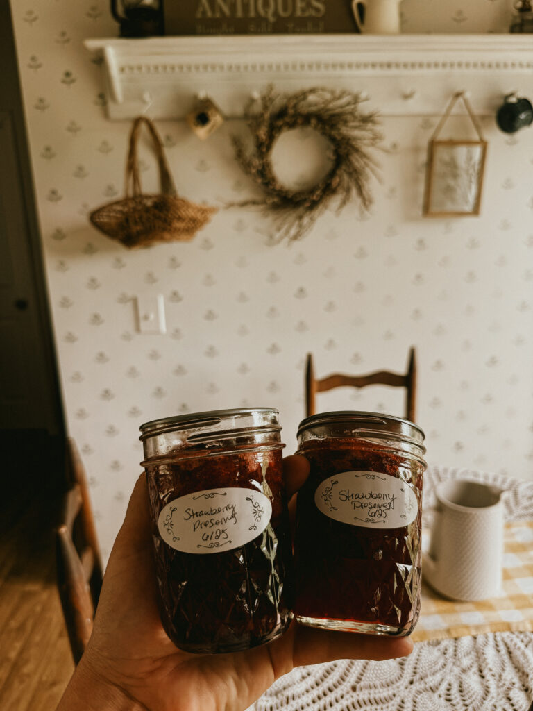 Strawberry preserves in  jars by a rustic table